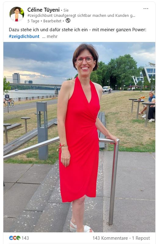 Hier siehst Du noch ein Foto von mir, Céline Tüyeni, in knallrot. Ich stehe auf einer Steintreppe vor dem Rhein.